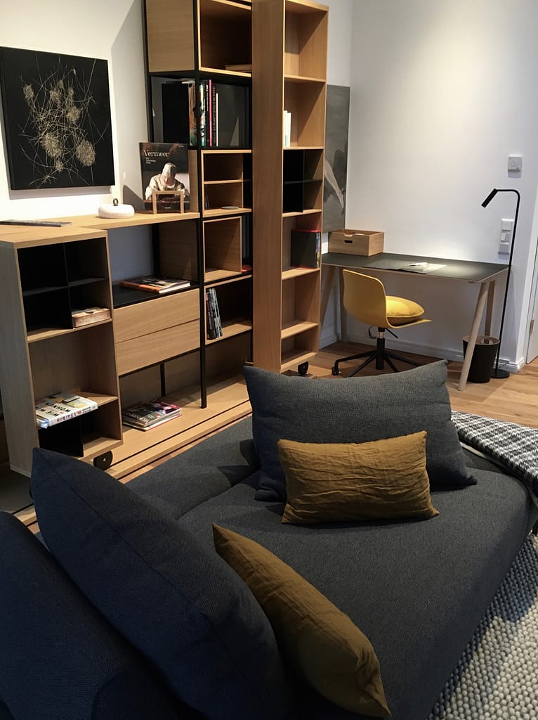 Moderner Arbeitsplatz mit Design-Regalsystem im Design Apartment Detmold